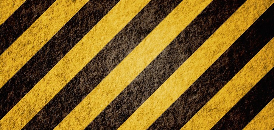 Gelbe Streifen auf schwarzen Grund, Absperrband.