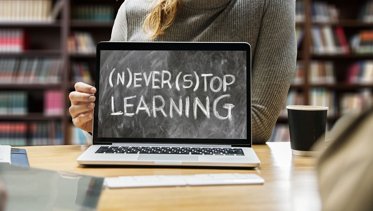 Frau hält den englischen Schriftzug "Never stop learning."
