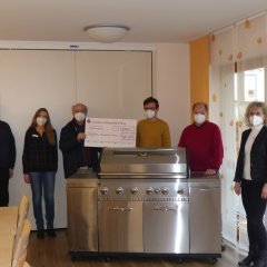 Vertreter des evangelischen Altenzentrums sowie den Fördervereins präsentieren den erhaltenen Scheck und den von den Fördermitteln erworbenen Gasgrill.