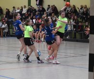 Handballspielerin beim Torwurf vor vollen Rängen