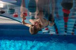Junge beim Klettern in der Waterclimbingwand