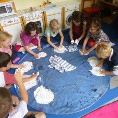 Kinder sitzen im Kreis und bereiten Lebensmittel vor.