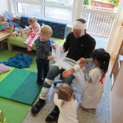 Kinder spielen mit Verbandsmaterial