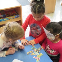 Kinder beim Spiel mit kleinen Pappgegenständen
