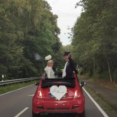 Foto eines Brautpaares in einem Auto