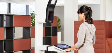 Stand-Aufbau des PointIDmit Bedieneinheit: Bürgerin bei Fingerabdruckerfassung